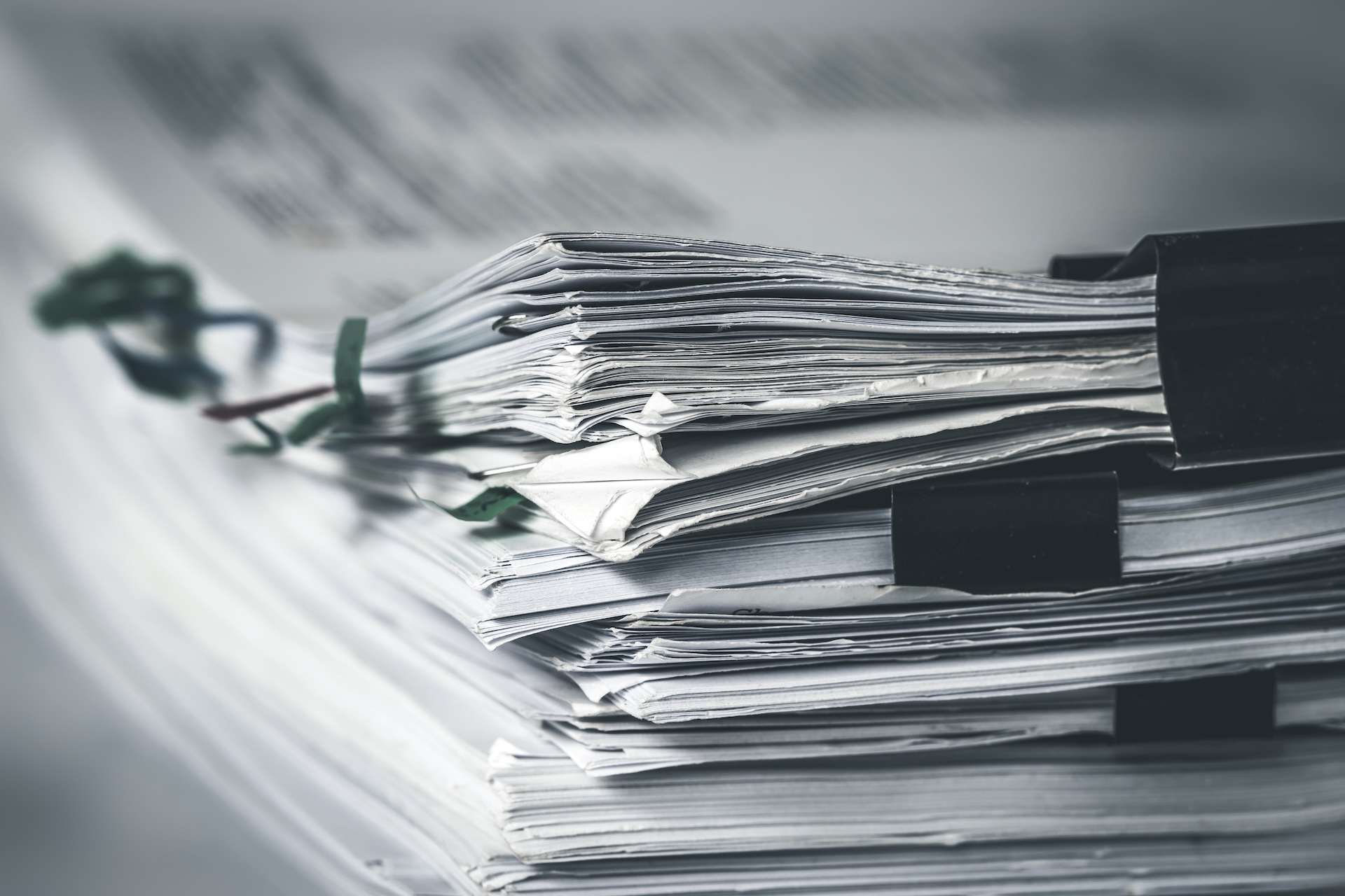 Stack of business records held together with binder clips