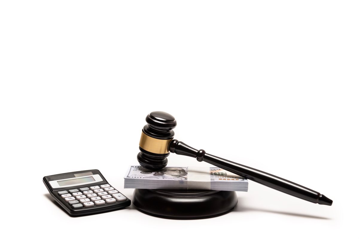 A judge's gavel resting on a stack of cash beside a calculator, representing the fines and financial costs of a DWI conviction. A judge's gavel resting on a stack of cash beside a calculator, representing the fines and financial costs of a DWI conviction.