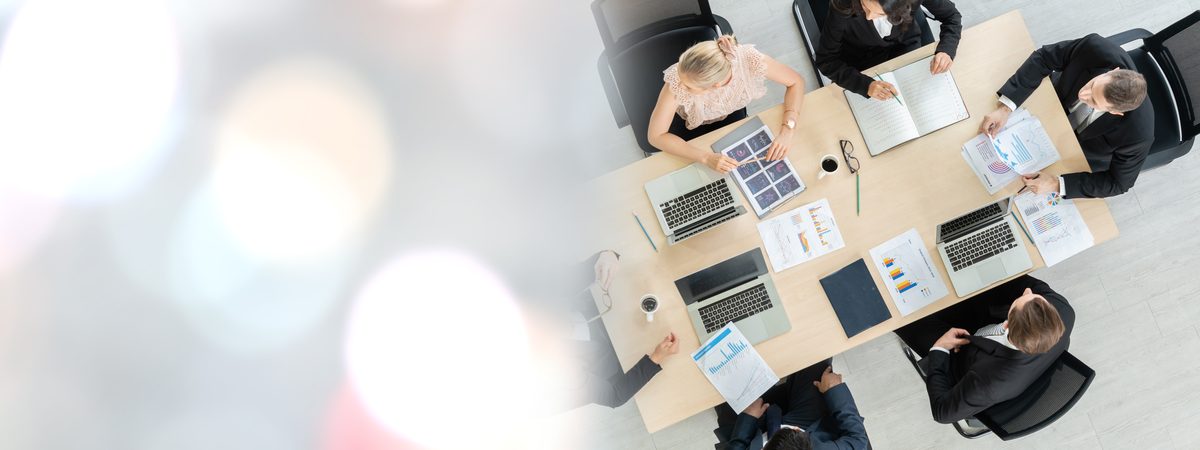 Business owners reviewing company governance documents around a conference table