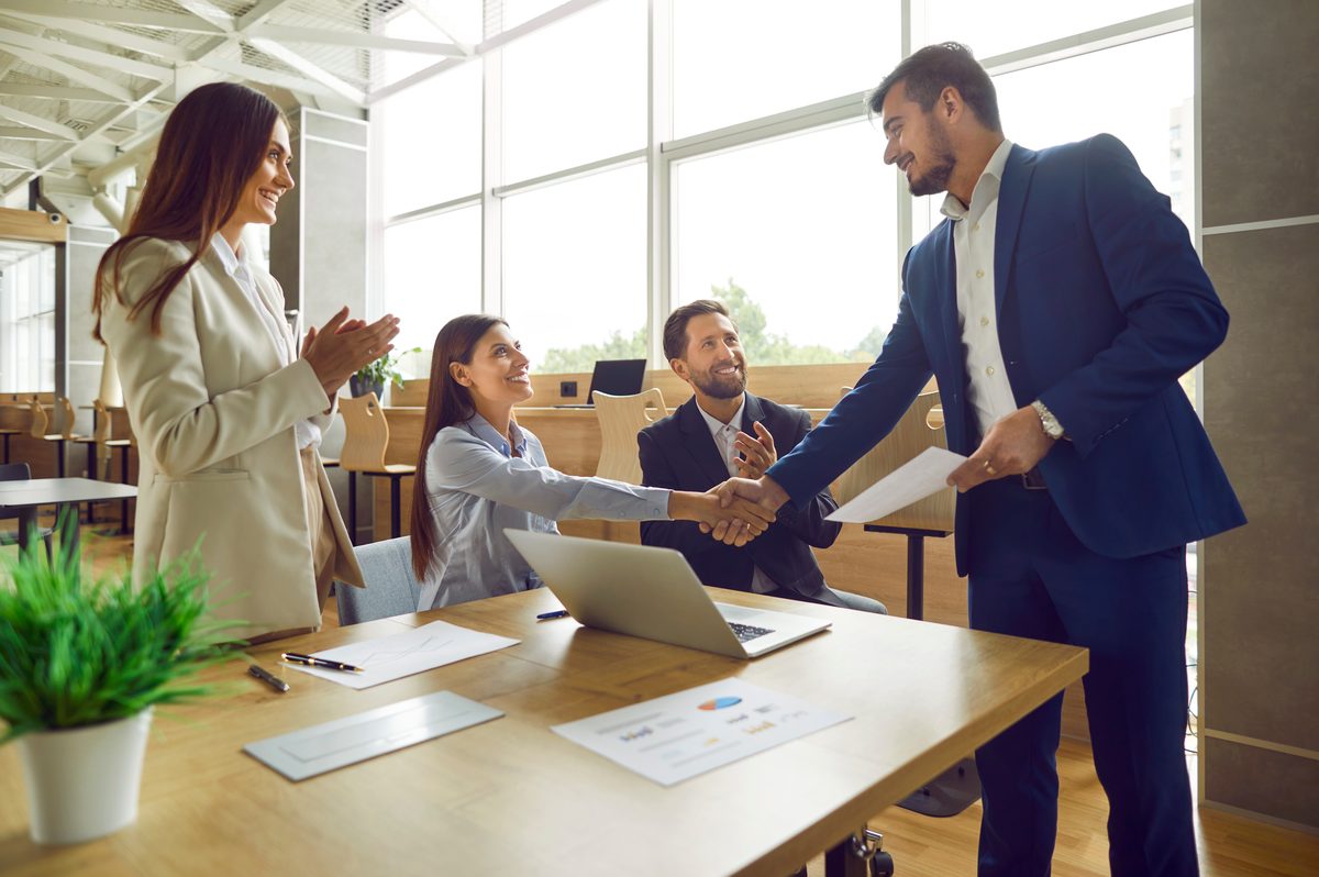 Business owner and buyer shaking hands after signing a purchase agreement