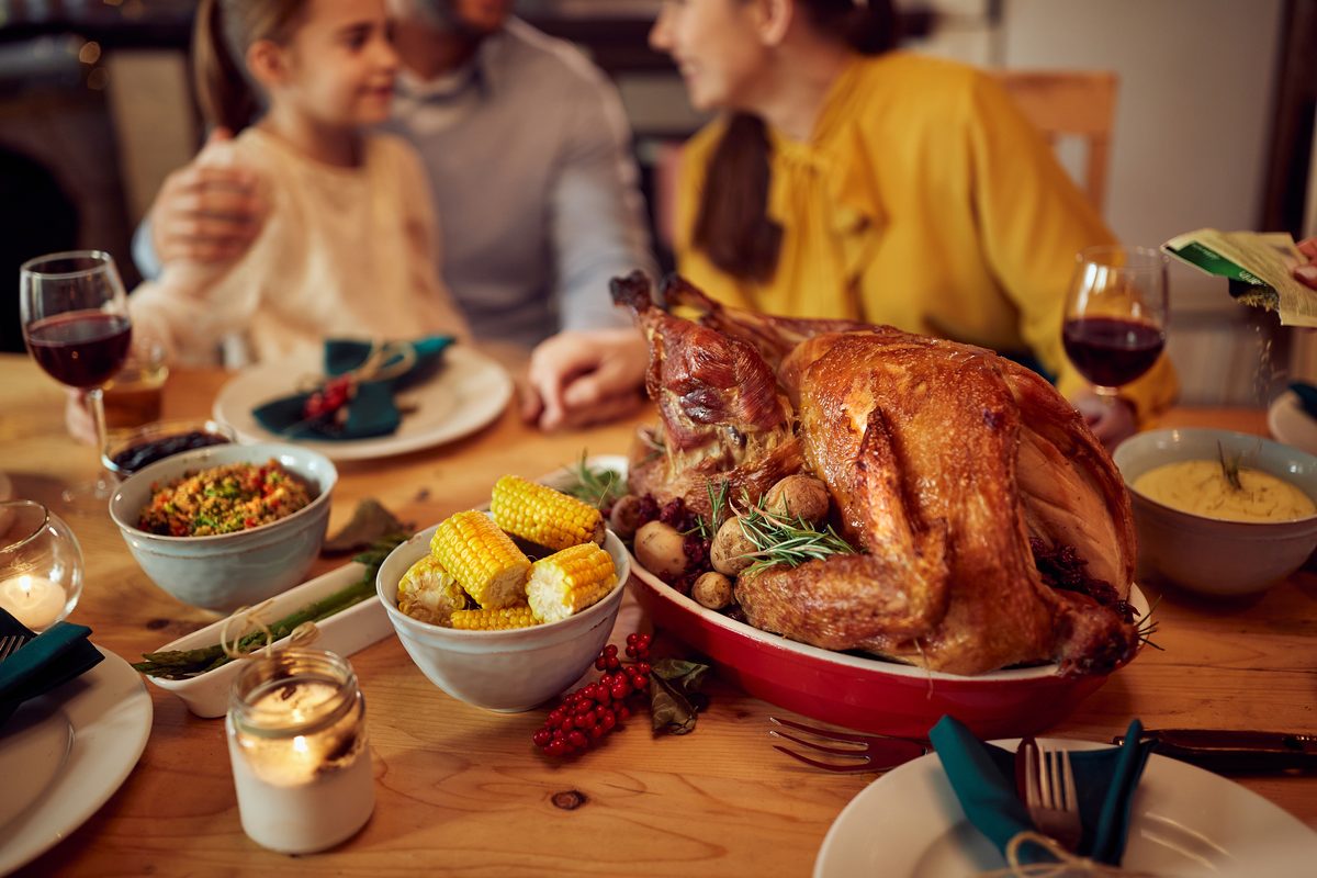 A family gathered around a table sharing a holiday meal together. A family gathered around a table sharing a holiday meal together.